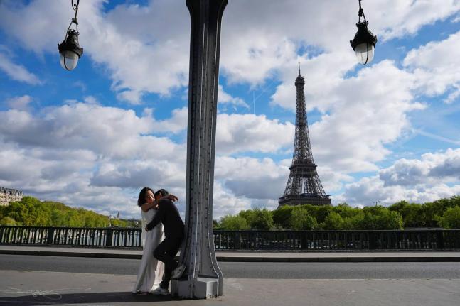 Tourists walk past the Eiffel Tower after it reopened following a one-day strike over restrictions on women during a visit by a Hindu delegation in Paris on September 8.