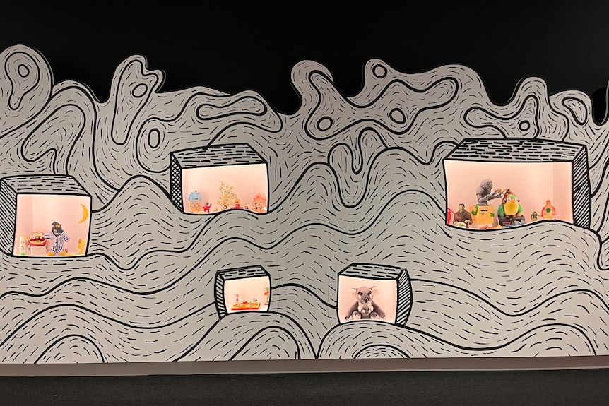 An exhibition of objects from the home of Andy Griffiths displayed through windows in a swirl-patterned background.